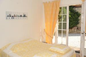 a bedroom with a bed and a large window at Maison des Cigales a heavenly setting in Saumane-de-Vaucluse