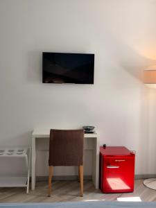 a room with a desk with a chair and a television at B&B Perbacco Relax in Mezzolombardo