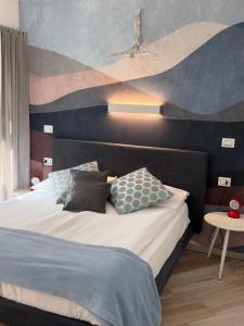 a bedroom with a bed with a painting on the wall at B&B Perbacco Relax in Mezzolombardo