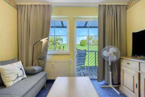 a living room with a couch and a tv and a window at Apartment mit Gartenblick K1 201 in Spalt
