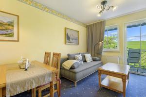a living room with a couch and a table at Apartment mit Gartenblick K1 201 in Spalt