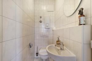 a white bathroom with a sink and a toilet at Apartment mit Gartenblick K1 201 in Spalt +15 photos