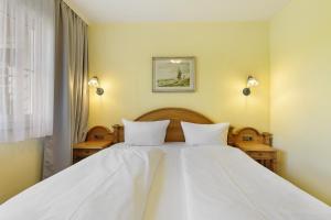 a large white bed with two white pillows at Apartment mit Gartenblick K1 201 in Spalt