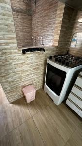 a kitchen with a stove and a pink stool at Flat Maracarib um espaço todo seu próximo de tudo in Maragogi