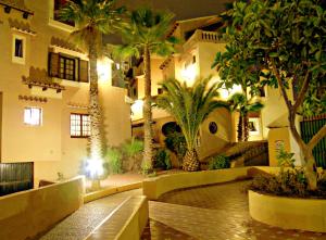 a building with palm trees and a building with lights at Ona Aldea del Mar in Torrevieja