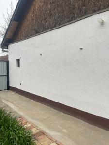 a white wall with a window on the side of a building at Orchidea Apartman in Bačka Topola