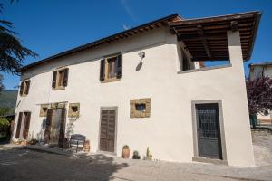 a white house with windows and a door at Il Pozzo degli Angeli in Cortona