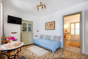 a living room with a blue bed and a table at Bougainvillea House in Parikia