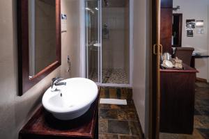 a bathroom with a sink and a shower at Zoete Rust Guesthouses in Lephalale +42 photos