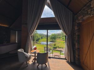 a room with a large window with a table and chairs at Guest house Etérea in Flores da Cunha