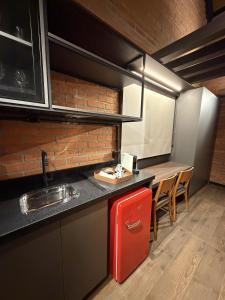 a kitchen with a red refrigerator and a table at Guest house Etérea in Flores da Cunha