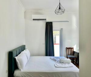 a bedroom with a bed with white sheets and a window at Hotel Iliria in Golem +12 photos