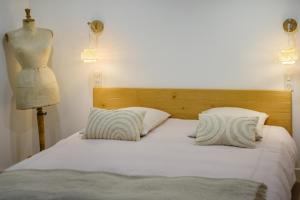 a bedroom with a bed with two pillows and a mannequin at Villa Cyprès Bleu in Peymeinade