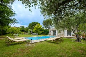 a pool in a yard with two lounge chairs and a house at Villa Cyprès Bleu in Peymeinade