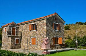 a stone house with a statue in front of it at Aura Seaside Apartments in Petra