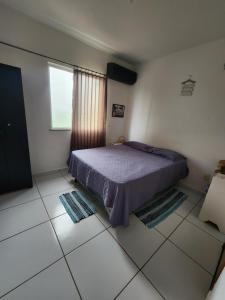a bedroom with a bed and a window and tiled floors at Morada Aconchegante com 2 quartos and Sofá Cama in Imperatriz +60 photos