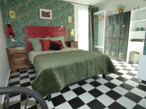 a bedroom with a bed and a checkered floor at Au Bal des Oiseaux in Chavagnes-en-Paillers