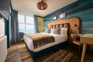 a bedroom with a bed with a blue wall at Great Western in Newquay