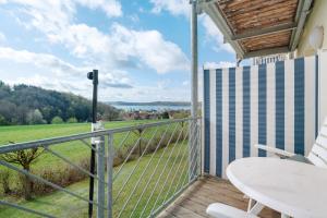 a balcony with a table and a view of a field at Superior Apt mit Seeblick K2 102 in Spalt