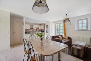 a dining room and living room with a table and chairs at Maison - Le Clos Des Pommiers in Pleudihen-sur-Rance +16 photos