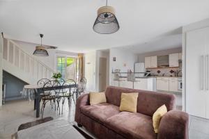 a living room and kitchen with a couch and a table at Maison - Le Clos Des Pommiers in Pleudihen-sur-Rance