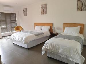 a bedroom with two beds and a chair at Magnolia Hotel in Middelburg +16 photos