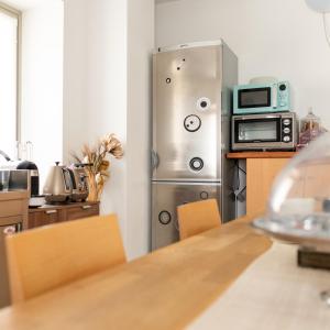 a kitchen with a stainless steel refrigerator and a microwave at B&B Perbacco Relax in Mezzolombardo