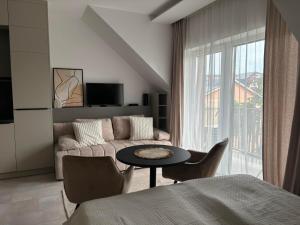 a living room with a couch and a table at LaMira 2,3 Apartments in Hajdúszoboszló
