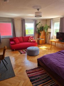a living room with a red couch and a table at Gästehaus Mohr in Eberhardzell
