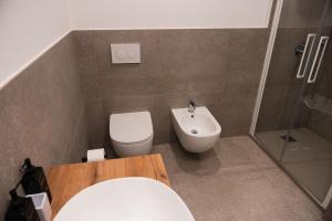 a bathroom with a toilet and a sink at Diamante Luxury Apartment in Torri del Benaco +2 photos