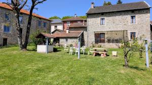 a picnic table in a yard next to a building at La forge in Saint-Julien-le-Petit