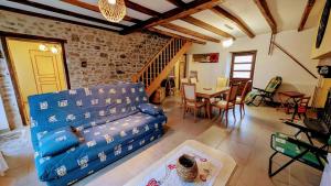 a living room with a blue couch and a table at La forge in Saint-Julien-le-Petit