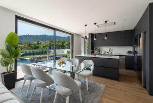 a kitchen and dining room with a glass table and chairs at Casinha da Ribeira in Vila Verde