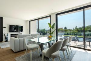 a living room with a glass table and chairs at Casinha da Ribeira in Vila Verde