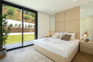 a bedroom with a large bed and a large window at Casinha da Ribeira in Vila Verde +37 photos