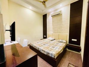 ein Schlafzimmer mit Bett, Schreibtisch und Fernseher in der Unterkunft MBH hotel in Tatārsar