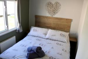 a bedroom with a bed with a wooden headboard at Saltwinds - Camber Sands in Camber