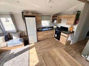 a kitchen with a couch and a table in a room at Saltwinds - Camber Sands in Camber