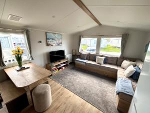a living room with a couch and a table at Saltwinds - Camber Sands in Camber