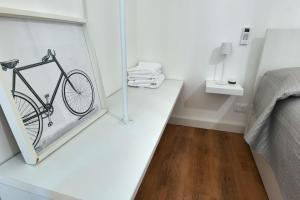 a painting of a bike on a table next to a bed at La Casa Della Zia Scicli in Scicli
