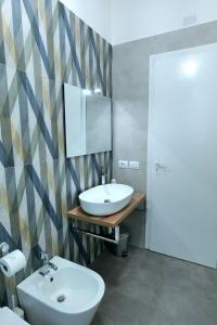 a bathroom with a sink and a toilet and a mirror at La Casa Della Zia Scicli in Scicli +1 photo