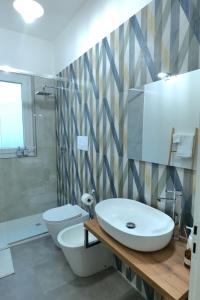 a bathroom with a white sink and a toilet at La Casa Della Zia Scicli in Scicli