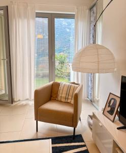a living room with a chair and a large window at One-Bedroom Apartment with Terrace, Sea View, Pool and Spa Lavender Bay Morinj in Donji Morinj