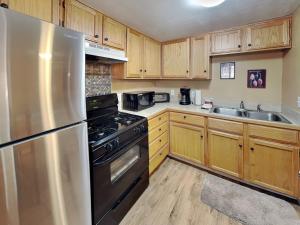 a kitchen with wooden cabinets and a stainless steel refrigerator at A Step Above in Ruidoso