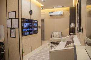 a waiting room with a couch and a chair and a tv at أجنحة لوسيل 3 Lucille Suites in Jeddah