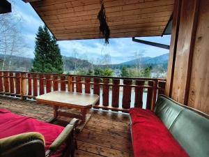 a wooden deck with a table and chairs on a balcony at Noclegi Kamionka in Cisna +12 photos