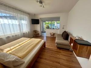a bedroom with a large bed and a couch at Gästehaus Sommertal, eigener Parkplatz, Pool, 800m zum Bodensee in Meersburg
