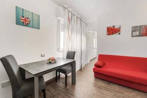 a living room with a table and a red couch at Mare e Relax in Quartucciu +15 photos