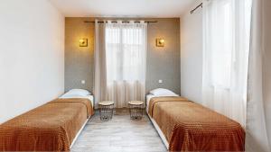 two beds in a room with a window at la porte medievale in Carcassonne