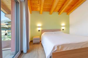 a bedroom with a white bed and a large window at Appartamenti Suly 3 - Cir0084 in Saint Vincent